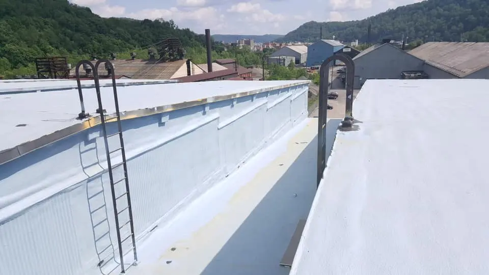 Professional spray foam roofing application in progress showing workers applying seamless waterproof barrier for superior insulation and energy efficiency